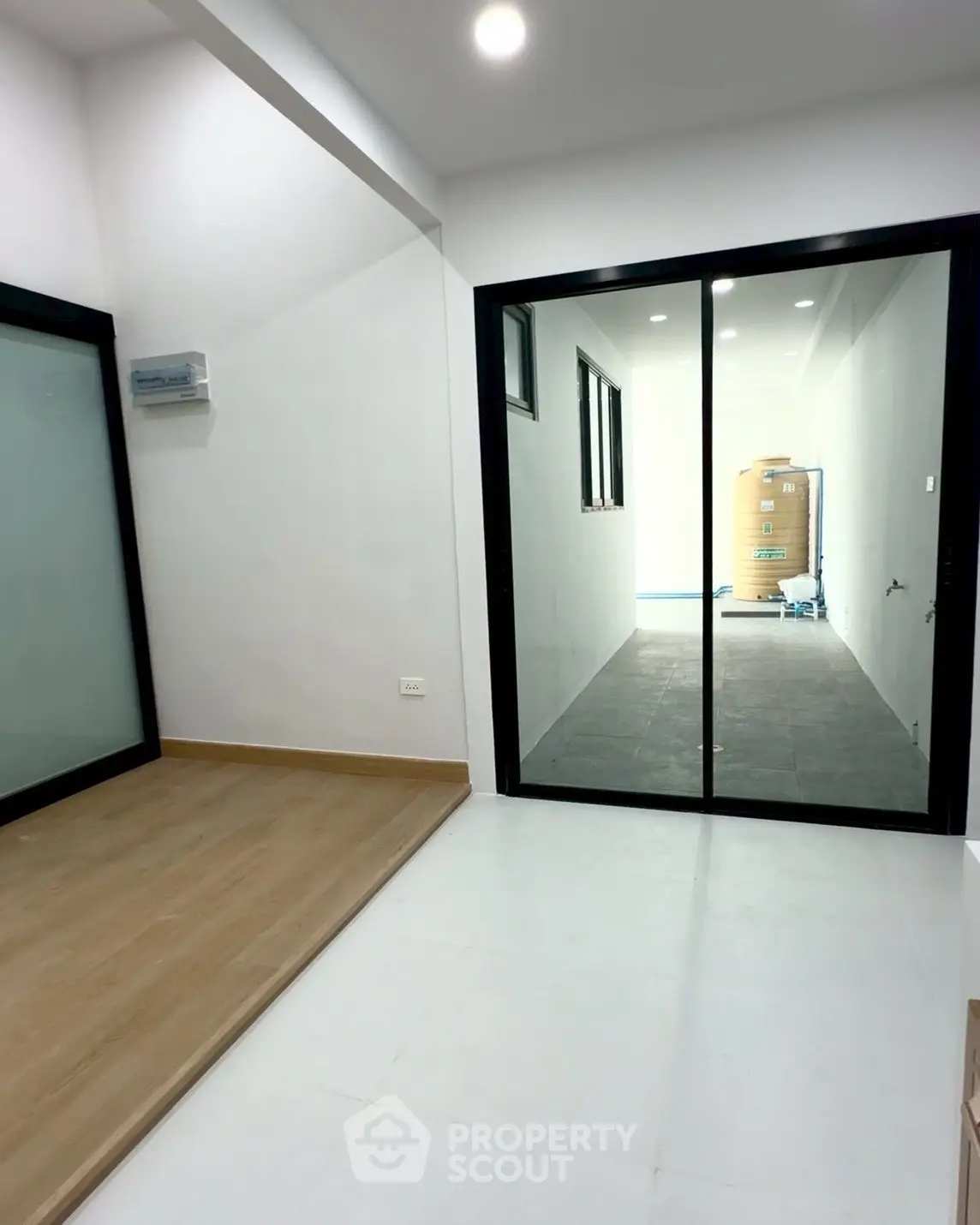 Modern interior space with sliding glass doors and wooden flooring, ideal for versatile living arrangements.