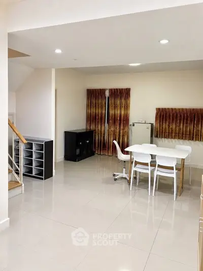 Spacious open-plan living area with modern dining set and ample natural light.