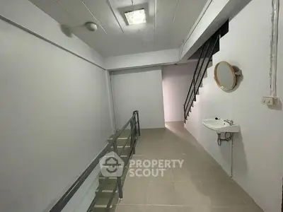 Spacious interior hallway with modern staircase and wall-mounted sink