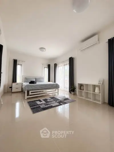 Spacious modern bedroom with large windows and minimalist decor
