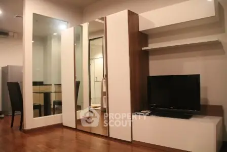 Modern living room with sleek furniture and wooden flooring in a stylish apartment.