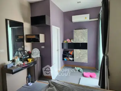 Cozy bedroom with modern decor and air conditioning, featuring a stylish vanity and ample storage space.