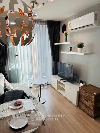 Modern living room with stylish decor, air conditioning, and natural light from large windows.