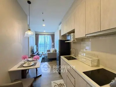 Modern open-layout kitchen and living room with stylish decor and natural light.