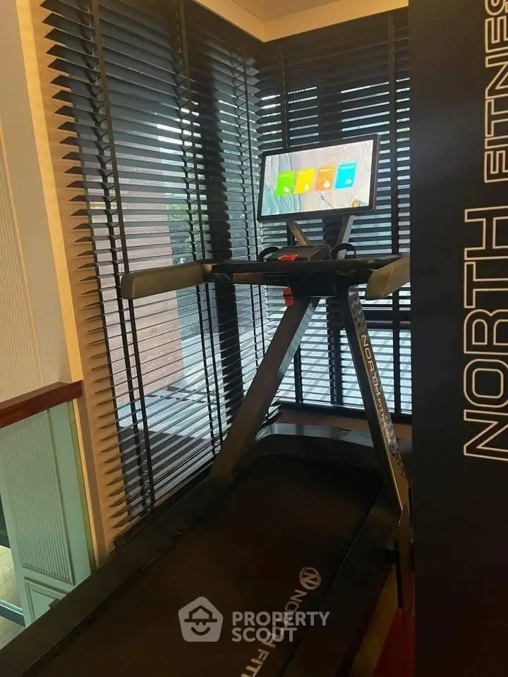 Modern gym with treadmill and digital display in luxury building