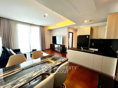 Luxurious open-plan living room with modern kitchen and elegant dining area, featuring sleek design and ample natural light.