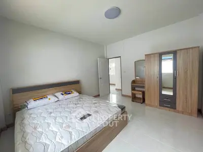 Spacious bedroom with modern wooden furniture and ample natural light