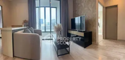 Modern living room with large windows and stylish decor in a high-rise apartment.