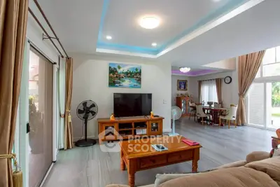 Spacious living room with modern decor and natural light, featuring a cozy seating area and entertainment center.