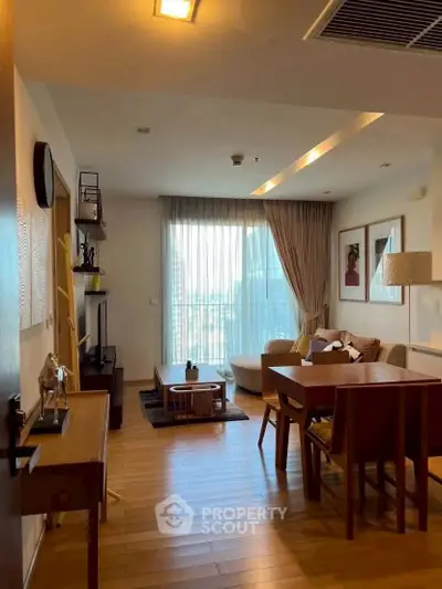 Spacious living room with modern decor and large window offering city view