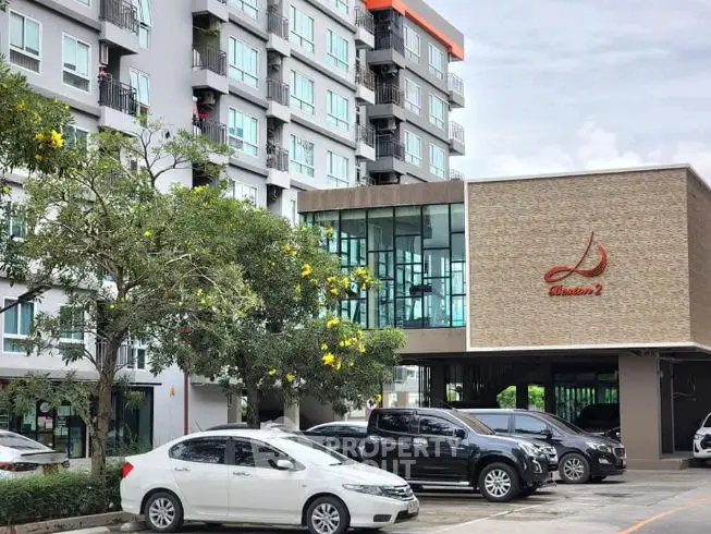 Modern apartment building with parking area and lush greenery, ideal for urban living.