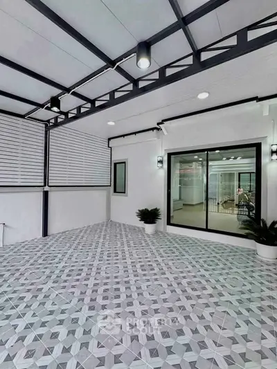 Modern covered patio with geometric tile flooring and sliding glass doors.