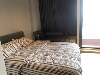 Cozy bedroom with striped bedding and balcony access