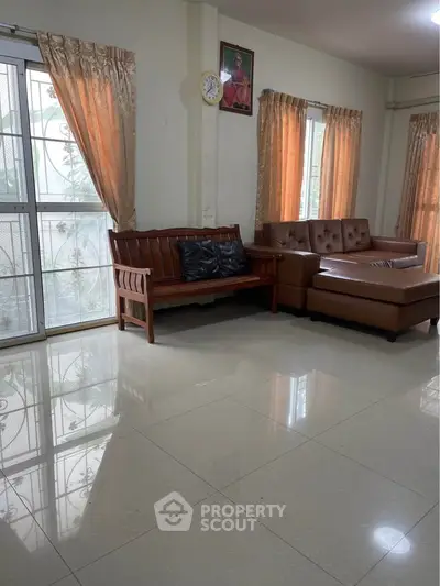 Spacious living room with elegant leather sofas and large windows for natural light.