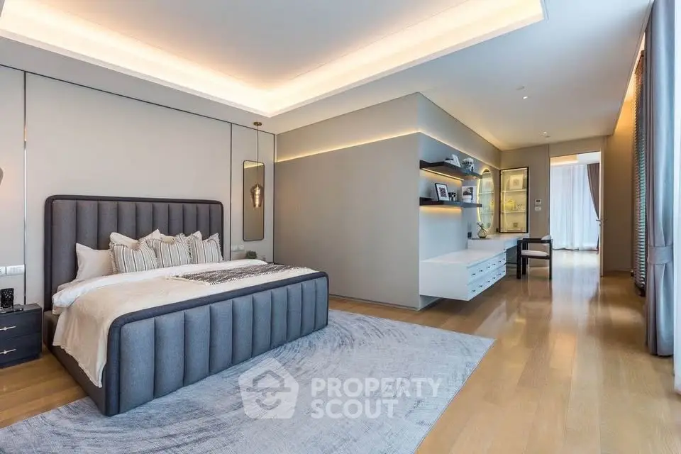 Luxurious modern bedroom with elegant decor and ample natural light, featuring a stylish bed and built-in shelving.