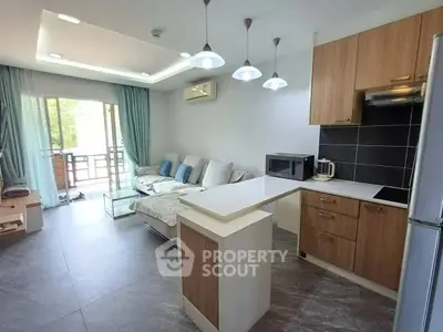 Modern open layout living room and kitchen with stylish decor and natural light.