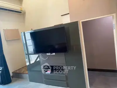Modern living room with sleek TV unit and air conditioning, perfect for cozy entertainment.