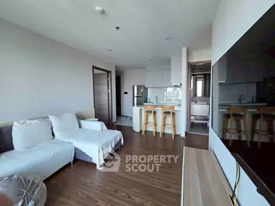 Modern living room with open kitchen and stylish furniture in a contemporary apartment.