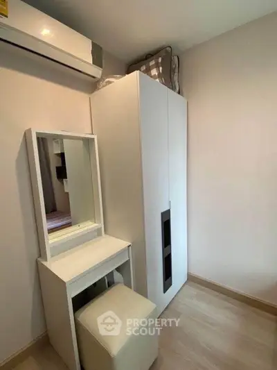 Cozy bedroom corner with wardrobe, vanity, and air conditioning in modern apartment.
