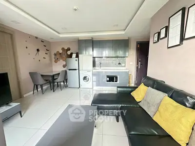 Modern living room with sleek furniture and integrated kitchen appliances.