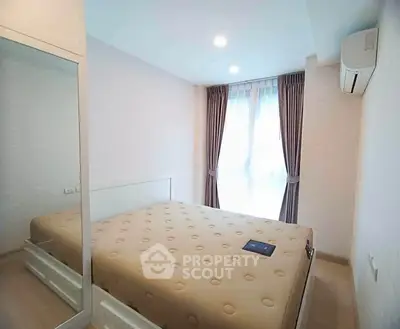 Bright and cozy bedroom with modern furnishings and large window for natural light.