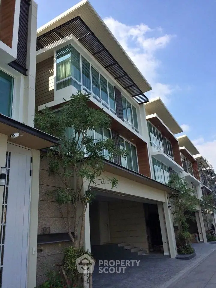 Modern multi-story residential building with large windows and contemporary design.