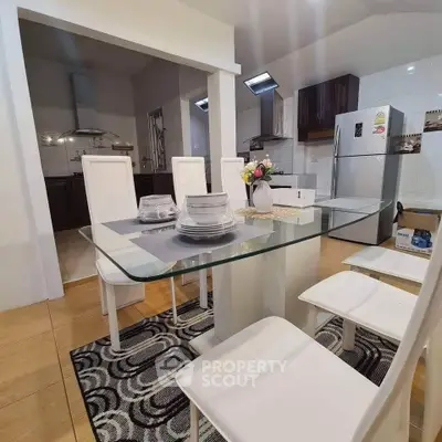 Modern dining area with glass table and stylish kitchen in open layout