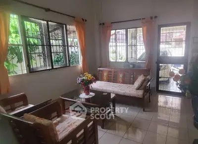 Charming living room with wooden furniture and garden view, perfect for cozy family gatherings.