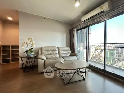 Spacious living room with modern sofa and large window offering city view