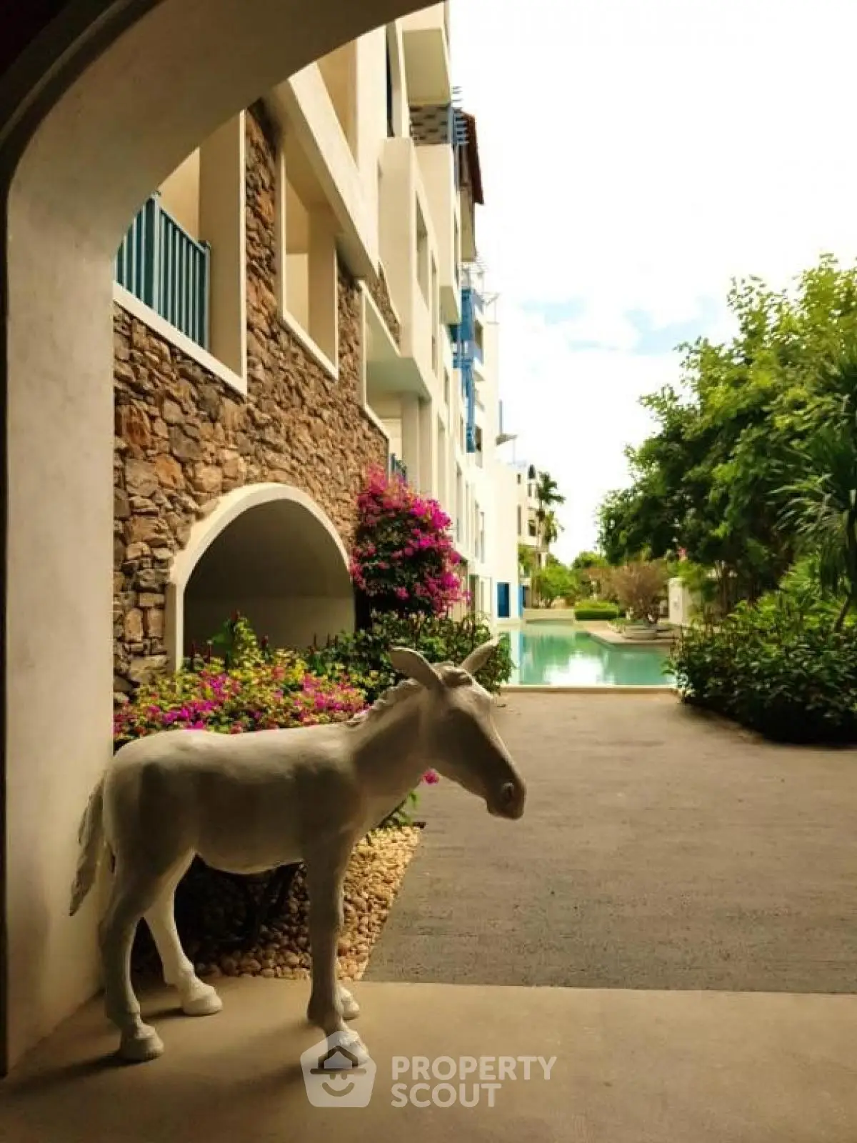 Charming garden view with unique sculpture and poolside ambiance
