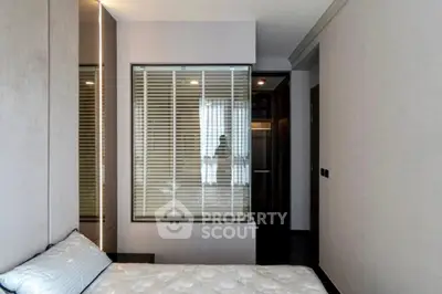 Modern bedroom with sleek design and large window for natural light.