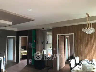 Modern living room with elegant decor and dining area, featuring stylish lighting and open layout.