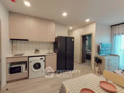 Modern kitchen with washing machine and fridge in open layout apartment