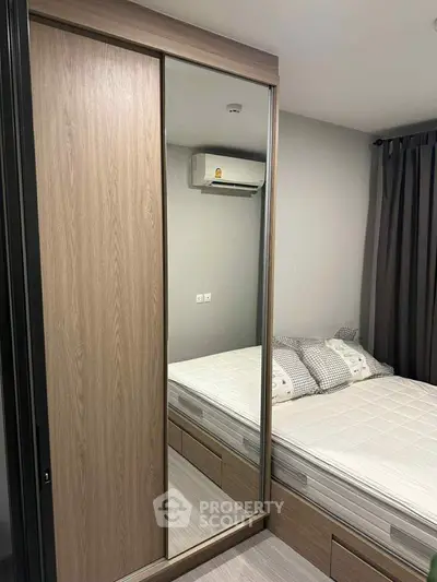 Modern bedroom with mirrored wardrobe and air conditioning