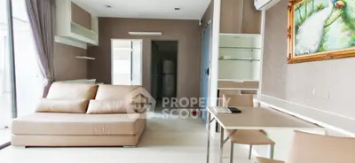 Modern living room with beige sofa, dining table, and stylish decor in a bright apartment.