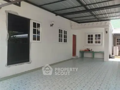 Spacious covered patio with tiled flooring and white walls, perfect for outdoor gatherings.