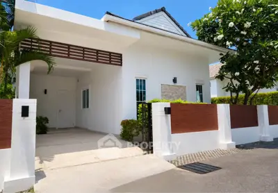 Charming modern house exterior with lush greenery and spacious driveway, perfect for family living.
