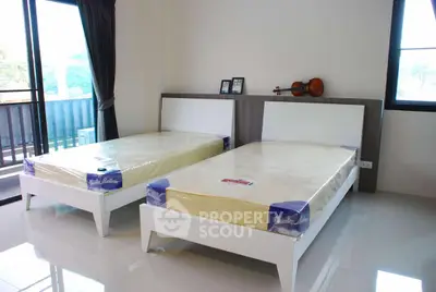 Spacious bedroom with twin beds and balcony access in modern apartment