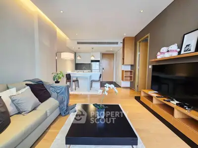 Modern living room with open kitchen, stylish decor, and cozy ambiance in a contemporary apartment.