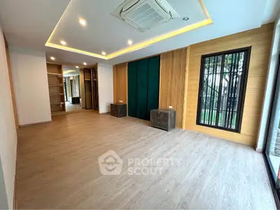 Spacious modern living room with wooden flooring and stylish ceiling lights