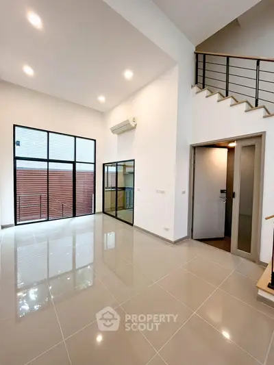 Spacious modern living room with high ceilings and large windows in a contemporary home.