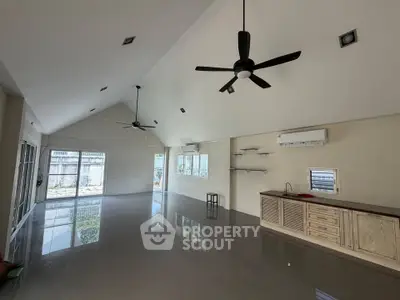 Spacious open-plan living area with high ceilings and modern fixtures, perfect for stylish living.