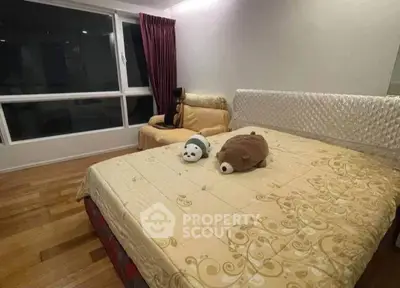 Spacious bedroom with elegant decor and large window offering natural light.