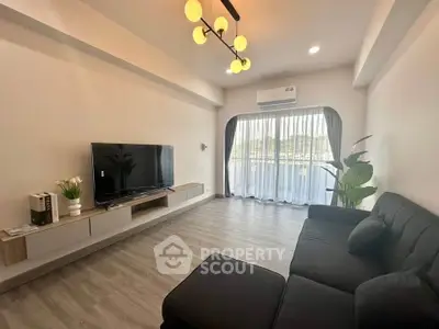 Modern living room with sleek furniture and large window for natural light.