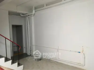 Spacious interior with exposed piping, ideal for renovation or creative design.