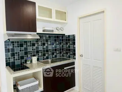 Modern kitchen with sleek cabinetry and stylish black tile backsplash
