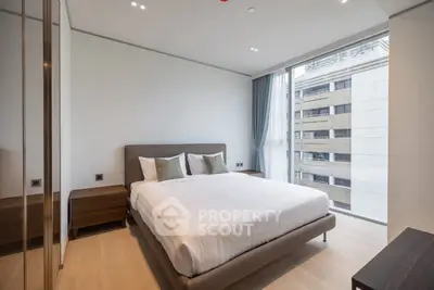 Modern bedroom with large window and stylish furnishings in a high-rise apartment.