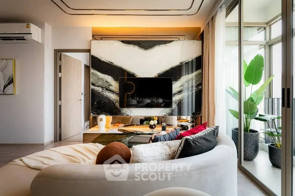 Luxurious living room with modern decor and large windows opening to a balcony.