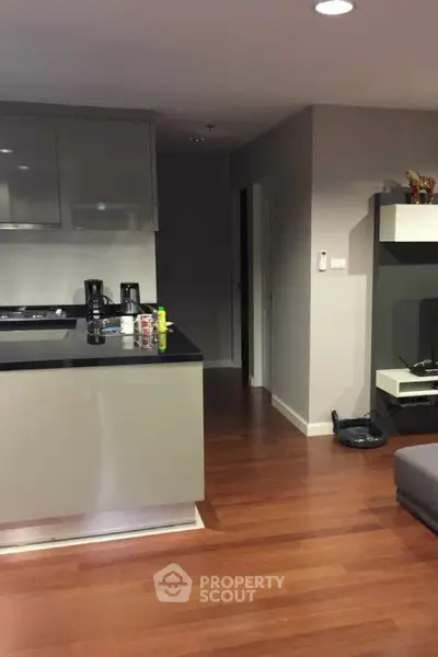 Modern kitchen with sleek cabinetry and hardwood floors in a stylish apartment.