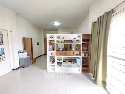 Spacious living room with large display shelves and natural light